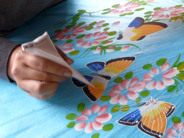 painting butterflies on umbrella in Baw Sang